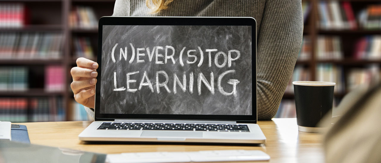 Text on the laptop: (n)ever (s)top learning